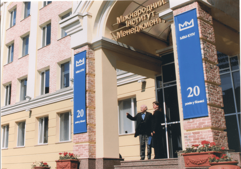 Двоє людей на вході до Міжнародного інституту менеджменту у Києві.