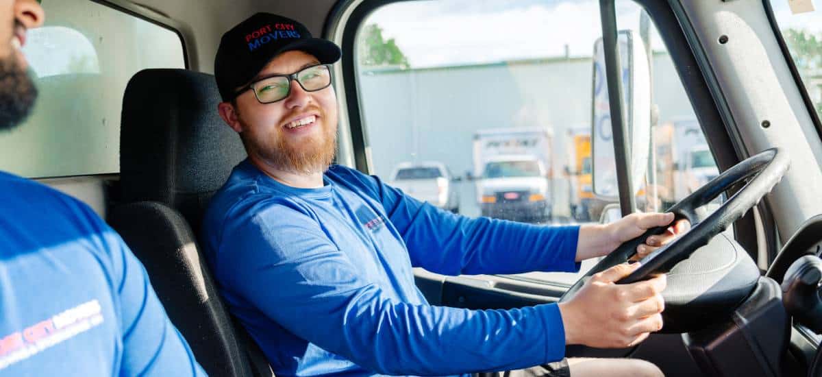 Mover from Port City Movers smiling while driving moving truck