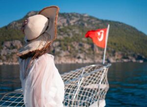 Woman in a sunhat enjoying a yacht trip in Bodrum with scenic views.