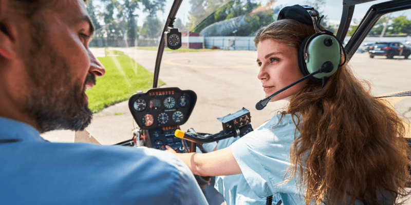 Young woman learning to pilot a yacht during an adventurous water activity.