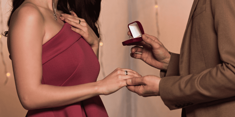 Romantic yacht proposal with couple exchanging rings on a luxury yacht.