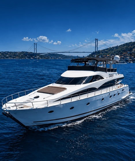 Modern luxury yacht available for rent on clear blue waters with a scenic bridge in the background.