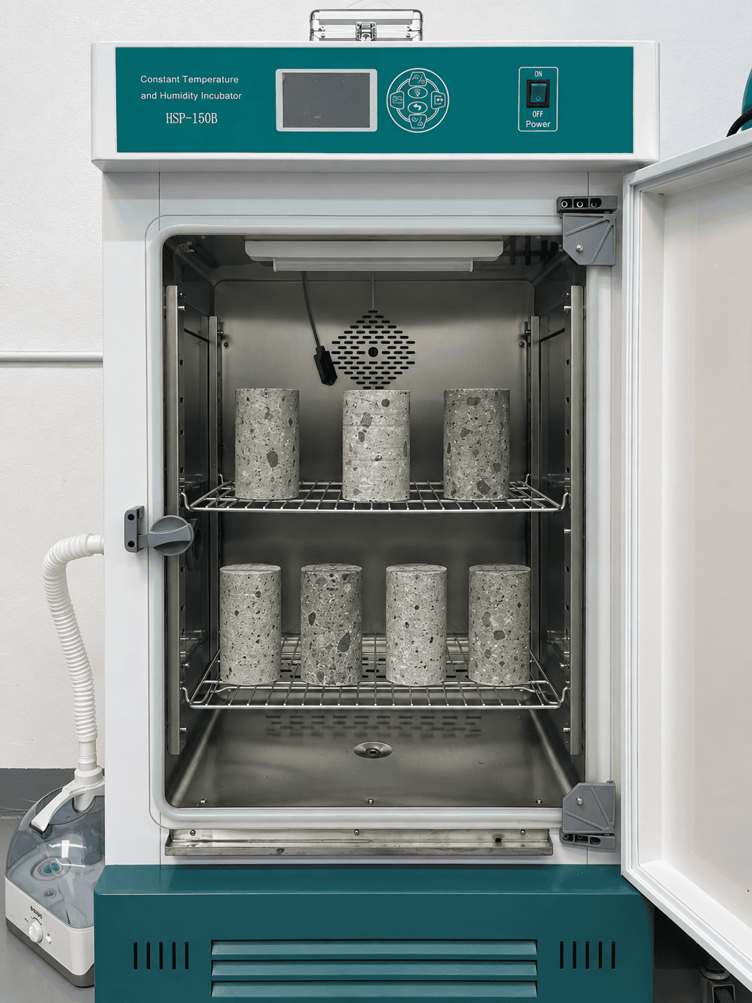 Concrete test cylinders curing in a temperature-controlled curing chamber