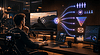 Person analyzing video content and marketing funnel on multiple screens.