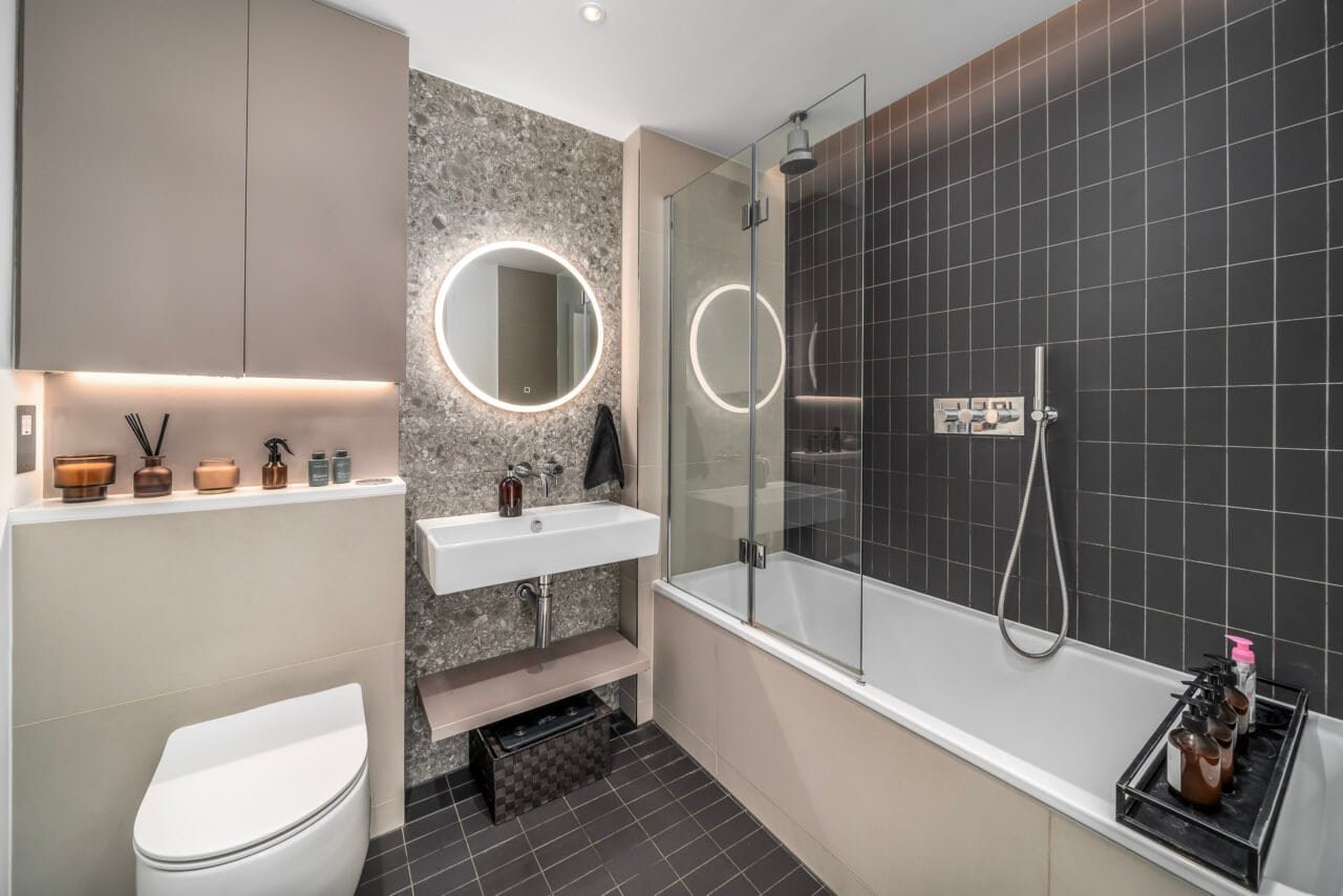 A modern bathroom with a bathtub, glass shower, and contemporary fixtures.