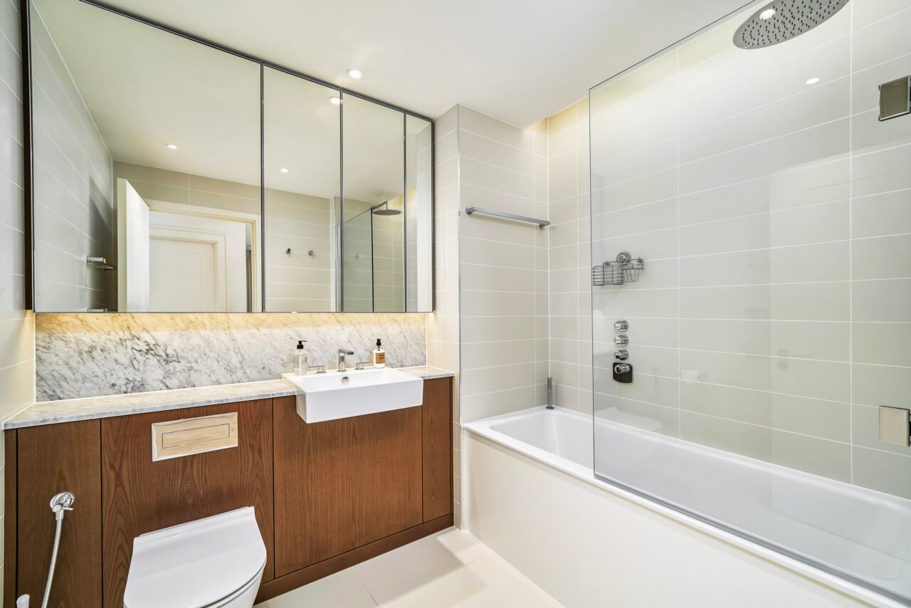 Modern bathroom with bathtub, shower, and vanity unit in a contemporary home.
