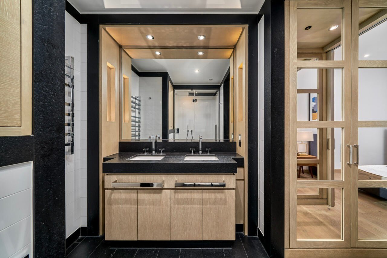 A modern bathroom vanity with dual sinks and wooden cabinetry in a contemporary interior.
