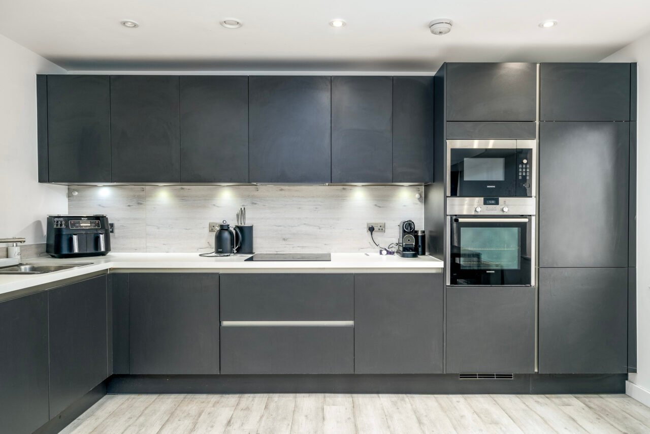 Modern grey kitchen with built-in appliances and minimalist design.