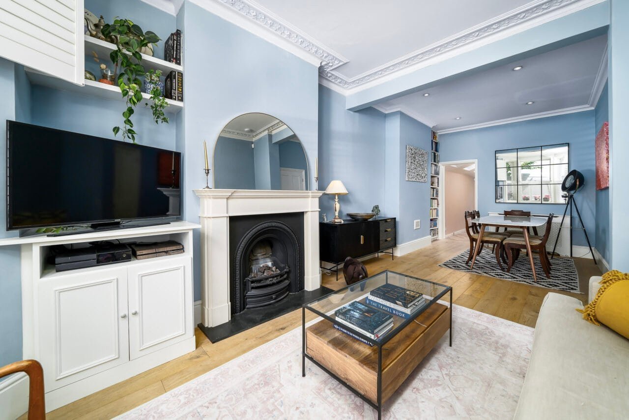 A modern living room with blue walls, fireplace, and stylish furniture.