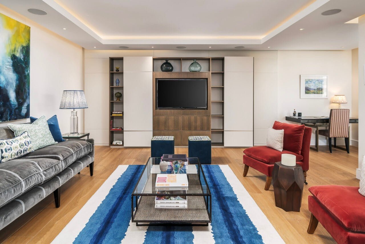 Modern living room with colourful furniture, TV unit, and stylish decor.