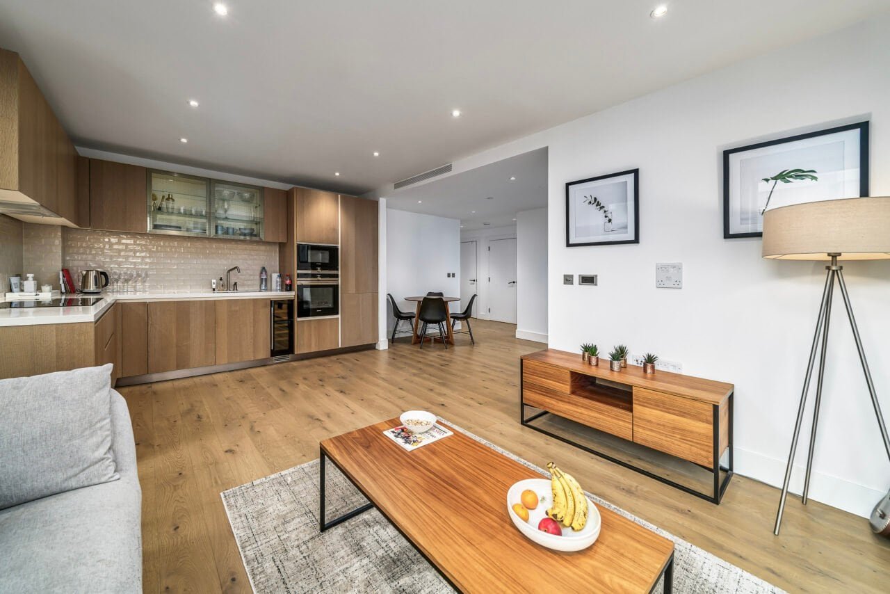 Modern open-plan living room with wooden flooring and contemporary decor.