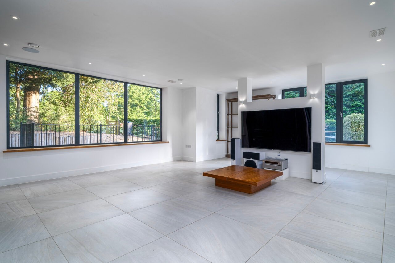 A spacious modern living room with large windows and minimalist decor.