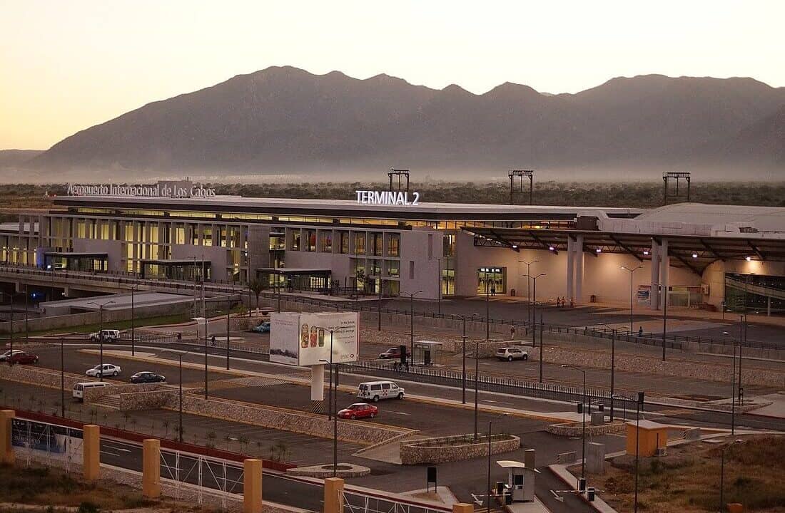 Puerto Los Cabos International Airport With Mountain Backdrop At Sunset, Showcasing Modern Architecture And Ongoing Traffic. Ideal For Real Estate Investments Near Scenic Baja California Sur Locations.