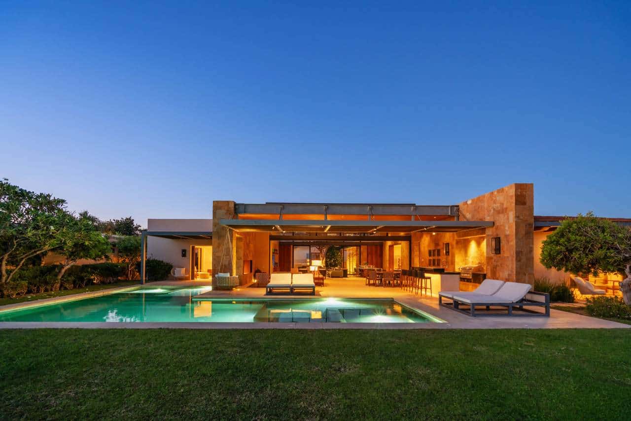 Luxurious Puerto Los Cabos Estate Featuring An Illuminated Pool, Modern Outdoor Living Space, And Stunning Architecture, Perfect For Luxury Real Estate Buyers In Puerto Los Cabos.