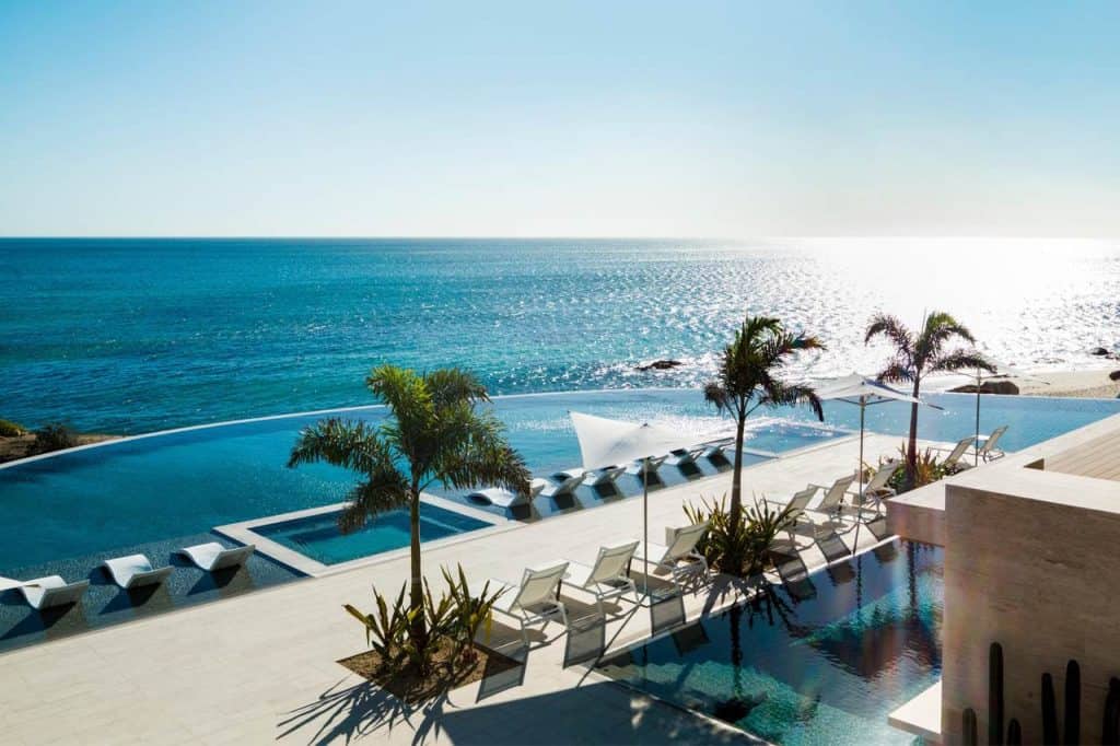 Luxurious Infinity Pool Overlooking The Ocean At Querencia Real Estate, Offering Stunning Sunset Views And A Perfect Relaxing Retreat.