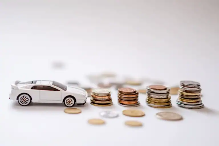 Foto de um mini carro com moedas em volta