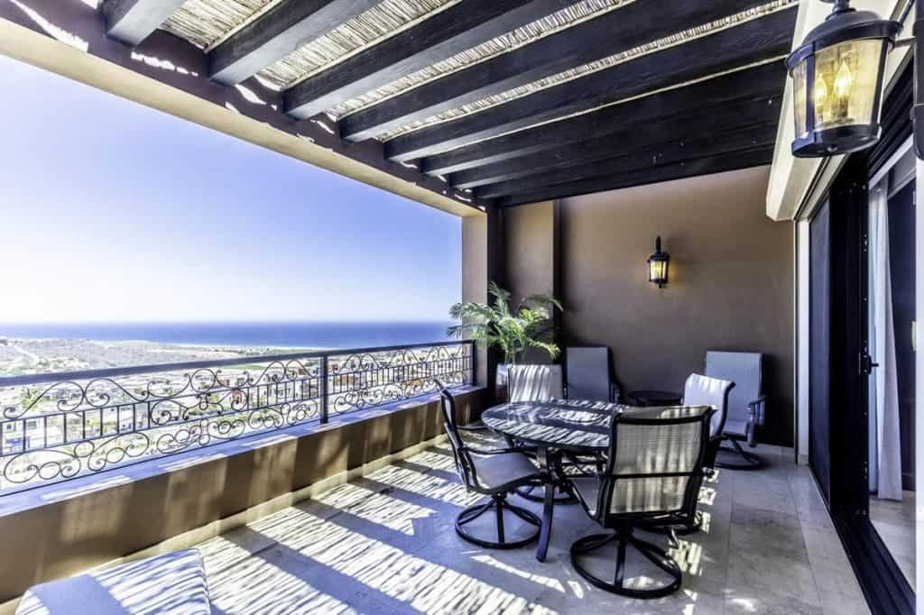 Private ocean-view terrace at Tower 5 Copala in Quivira Cabo San Lucas, featuring a dining table, chairs, and panoramic views of the Pacific Ocean.