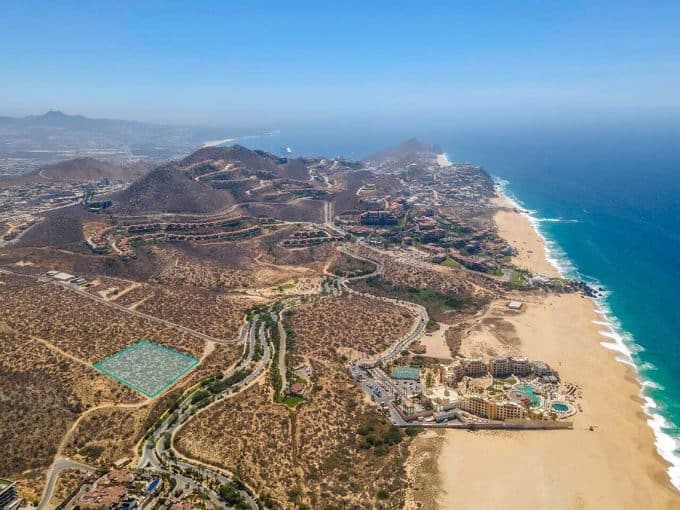 Luxurious Coastal Development At Quivira Los Cabos, Showcasing Hillside Properties And Ocean Views In A Prime Real Estate Location.