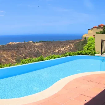 Private Pool With An Ocean View In A Quivira Luxury Villa, Featuring A Tiled Deck And Desert Landscaping.