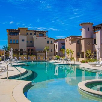 Quivira Resort Communal Pool Area Surrounded By Spanish Colonial Style Residential Buildings And Lounge Chairs.
