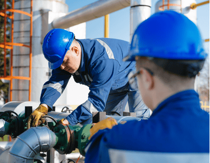 High-quality industrial automation technicians working on pipeline systems at an industrial plant, focusing on maintenance and safety.