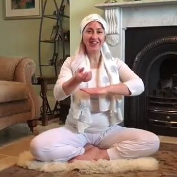 Woman practicing yoga in a cozy living room with a fireplace.