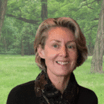 Portrait of Sally Bratton outdoors in a lush green forest setting.