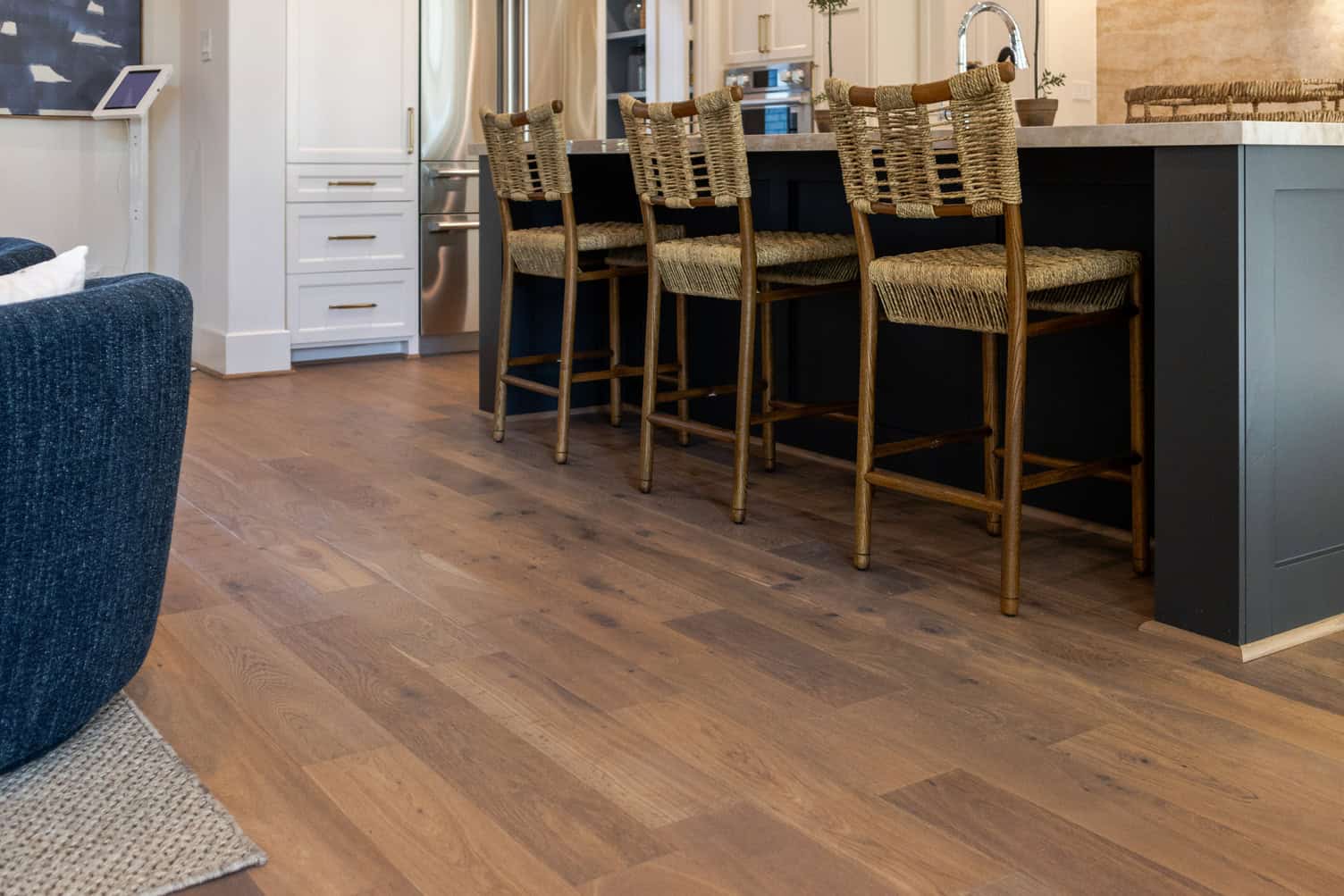 Surrey hardwood flooring in a contemporary kitchen with bar stools and natural wood finish.