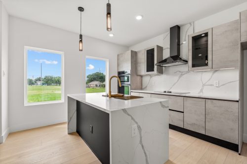 Close-up of modern kitchen island with black base and natural wood-look flooring