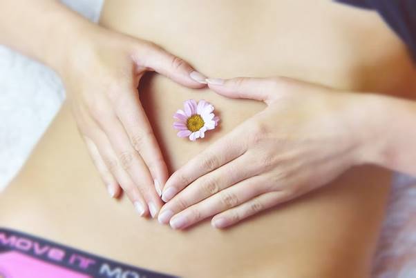 Soothing belly massage with a flower for relaxation and holistic wellness.