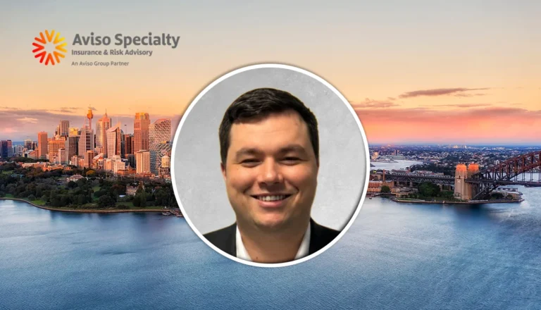 Smiling man portrait in a circular frame over a sunset city skyline with the Aviso Specialty logo in the top-left.
