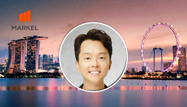 Circular headshot of a smiling man over a gray backdrop, with MARKEL branding and a Singapore skyline at sunset in the background.