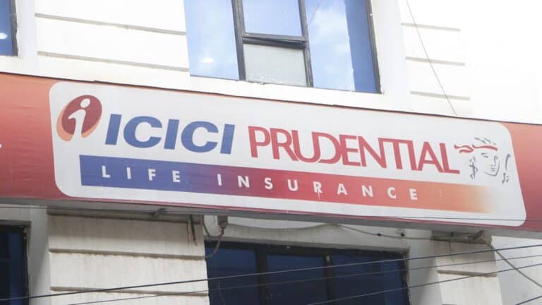 Signboard says ICICI PRUDENTIAL LIFE INSURANCE on a white banner with a blue–orange gradient and logo.
