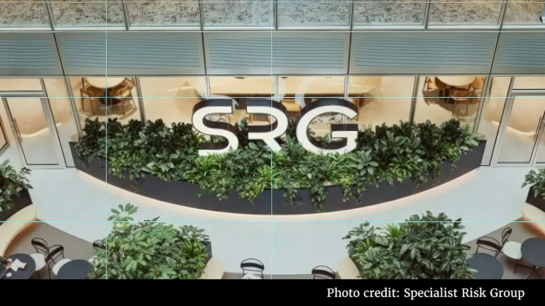 Indoor atrium with a lush green wall and a large SRG logo above it.