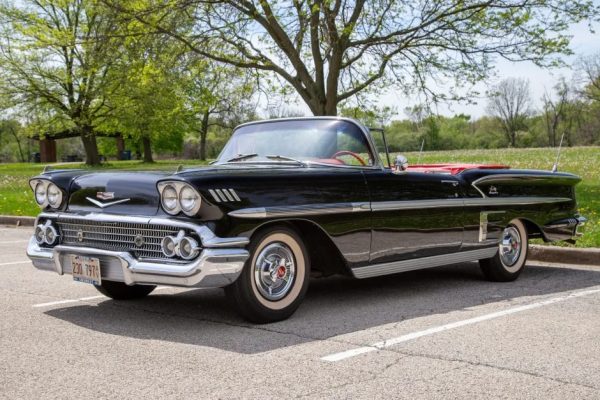 1950s vintage black Cadillac convertible parked outdoors with green trees in the background, showcasing classic car collectibles at RepoAuctionHouse.