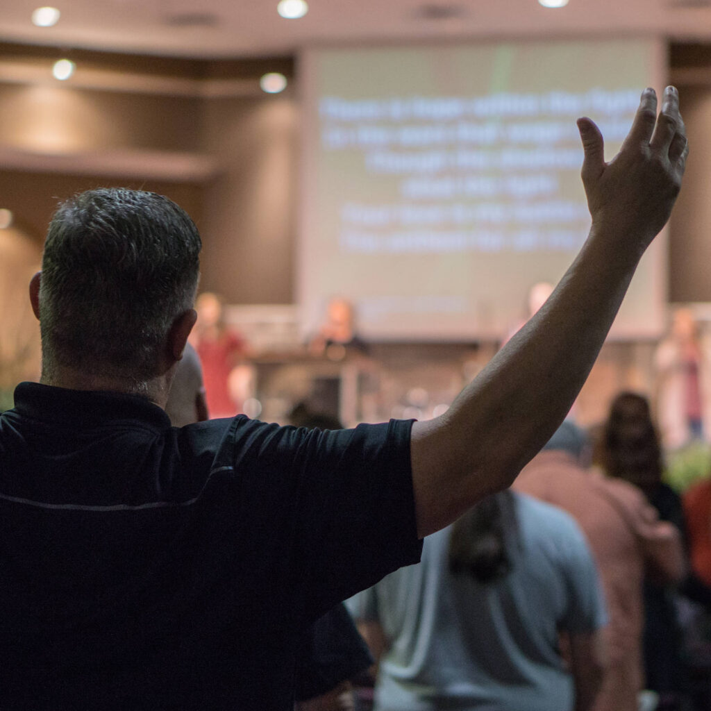 Man at church service raising his arms