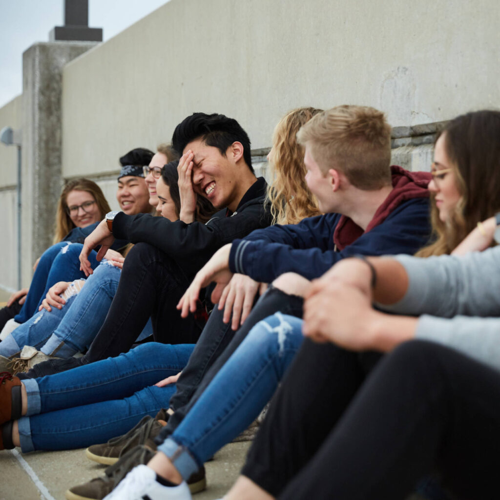 Group of young people sitting and laughing