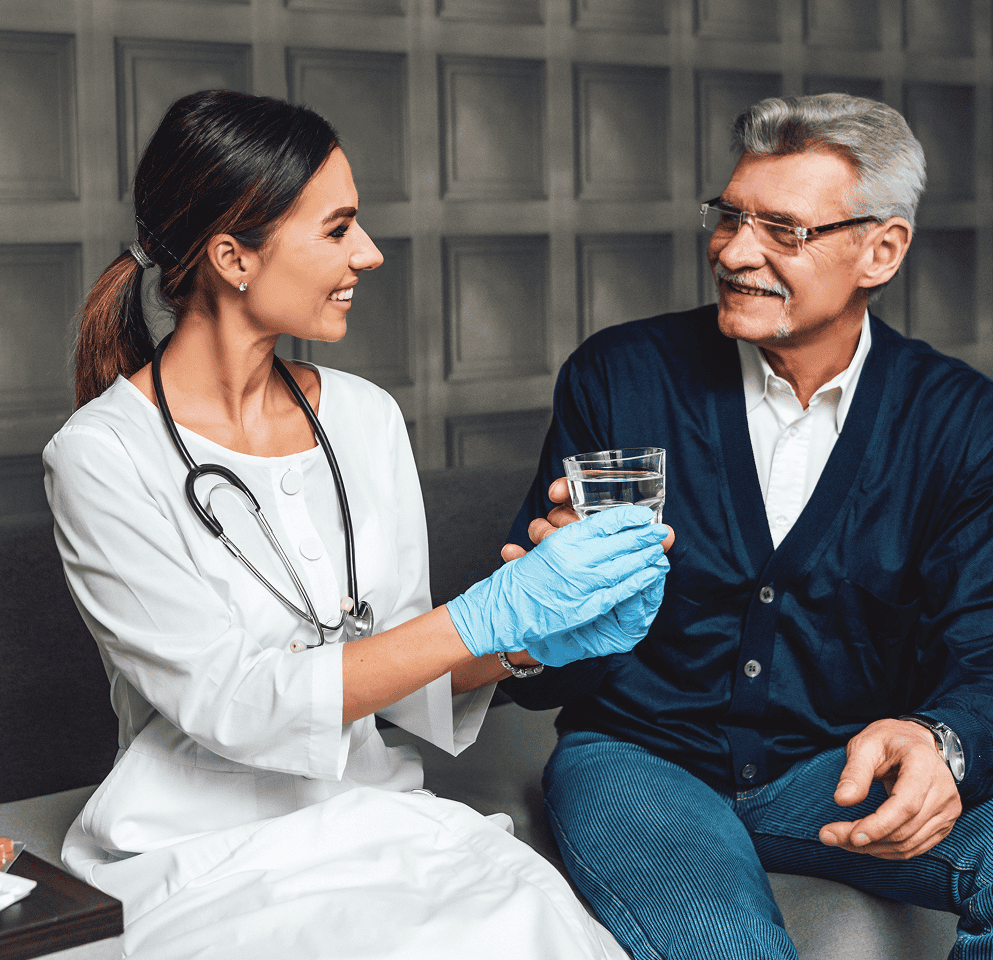 smiling young female doctor hands glass water older man helping caring elderly person 1