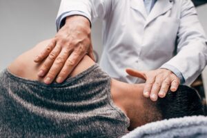 Relief chiropractic adjustment being performed on a patient's neck and shoulder.