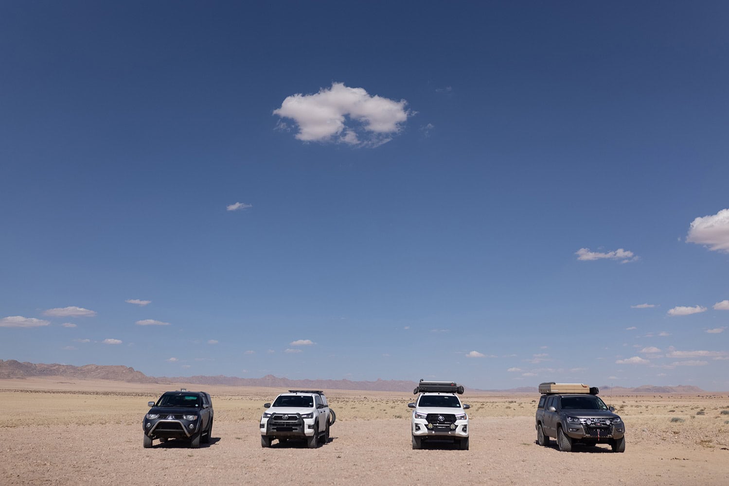 Sleek stainless steel canopies on off-road vehicles in a desert landscape, showcasing durable and modern outdoor car accessories from RLD Design.