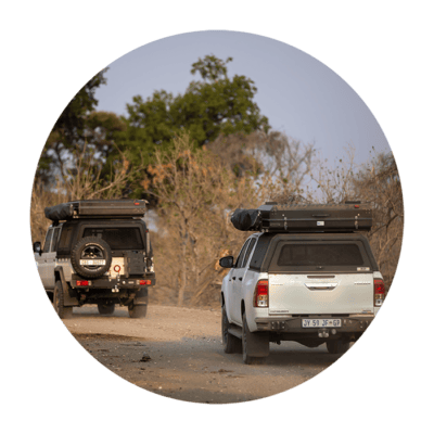 Two off-road vehicles with stainless steel canopies parked on a dirt road in a natural outdoor setting, showcasing durable and stylish canopy designs for rugged vehicles.