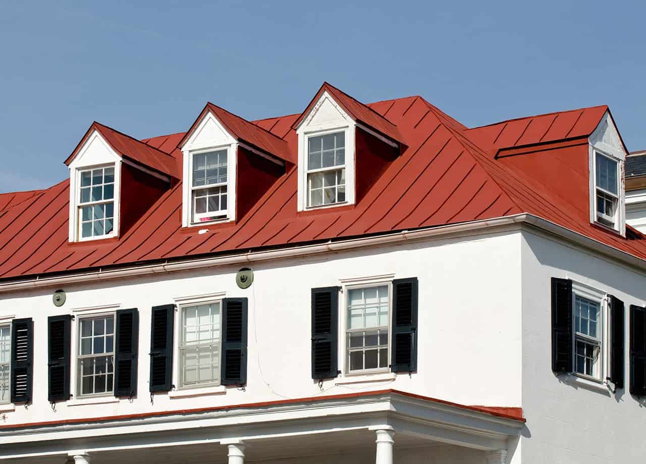 A photo of a roof with a gutter drain installed, advertising Roofing For Troops' gutter cleaning services