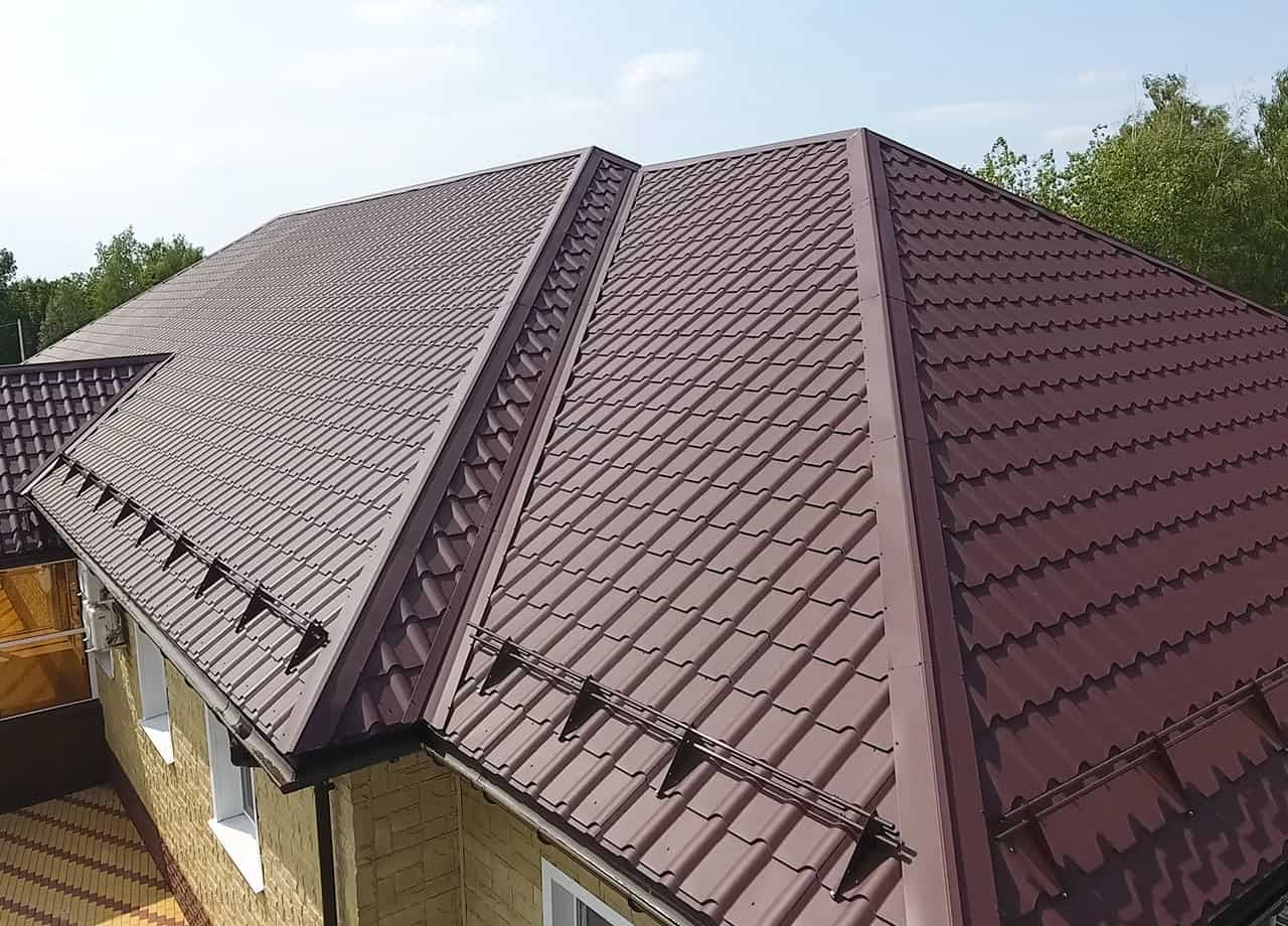 A photo of a roof with a gutter drain installed, advertising Roofing For Troops' gutter cleaning services