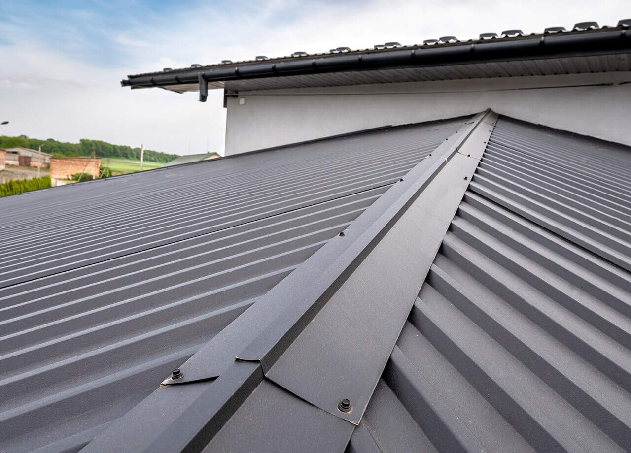 A photo of a roof with a gutter drain installed, advertising Roofing For Troops' gutter cleaning services