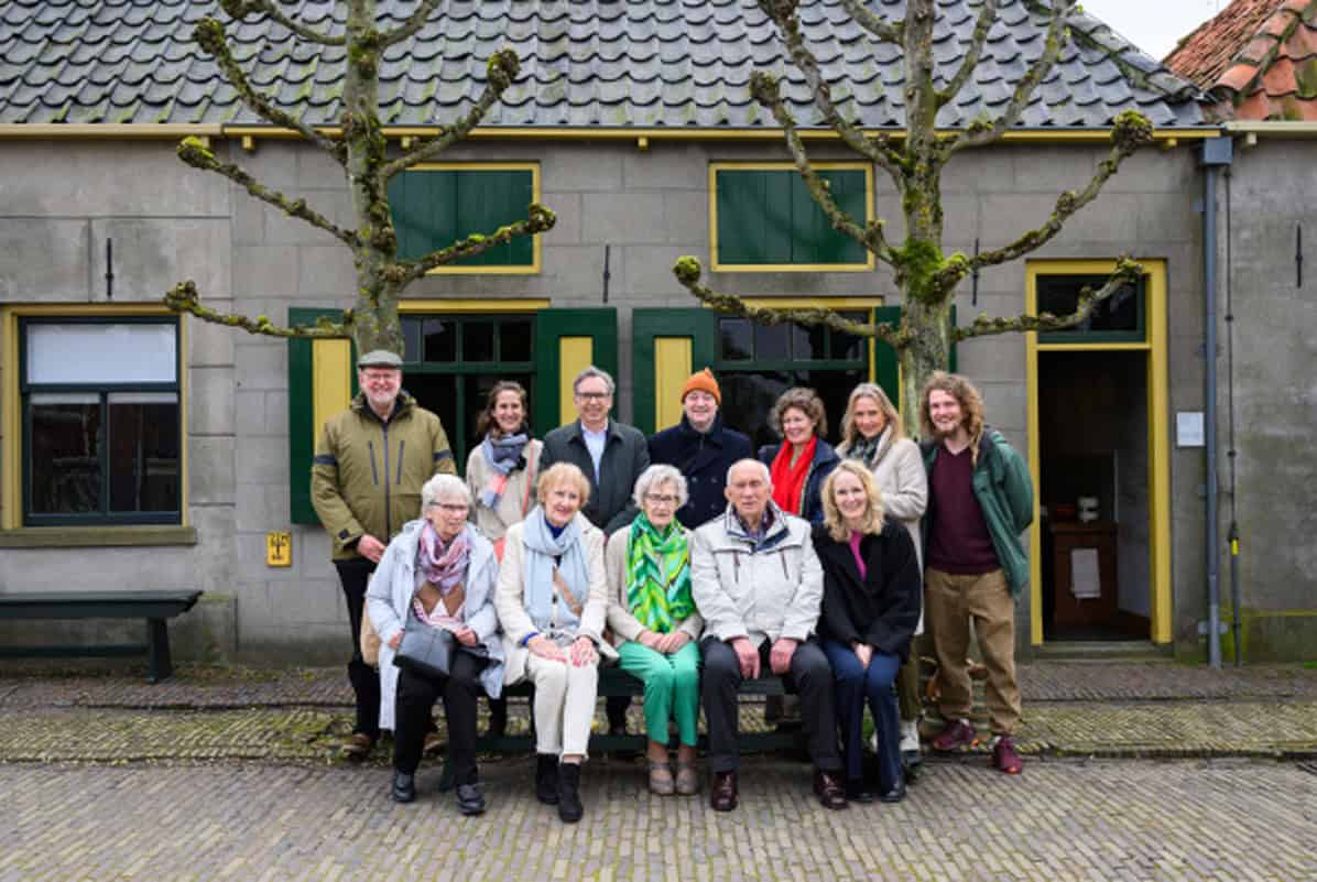 Familieleden van Anna Diender, museumvertegenwoordigers en Eva Vriend voor het Schokker huis, foto Studio Twisk
