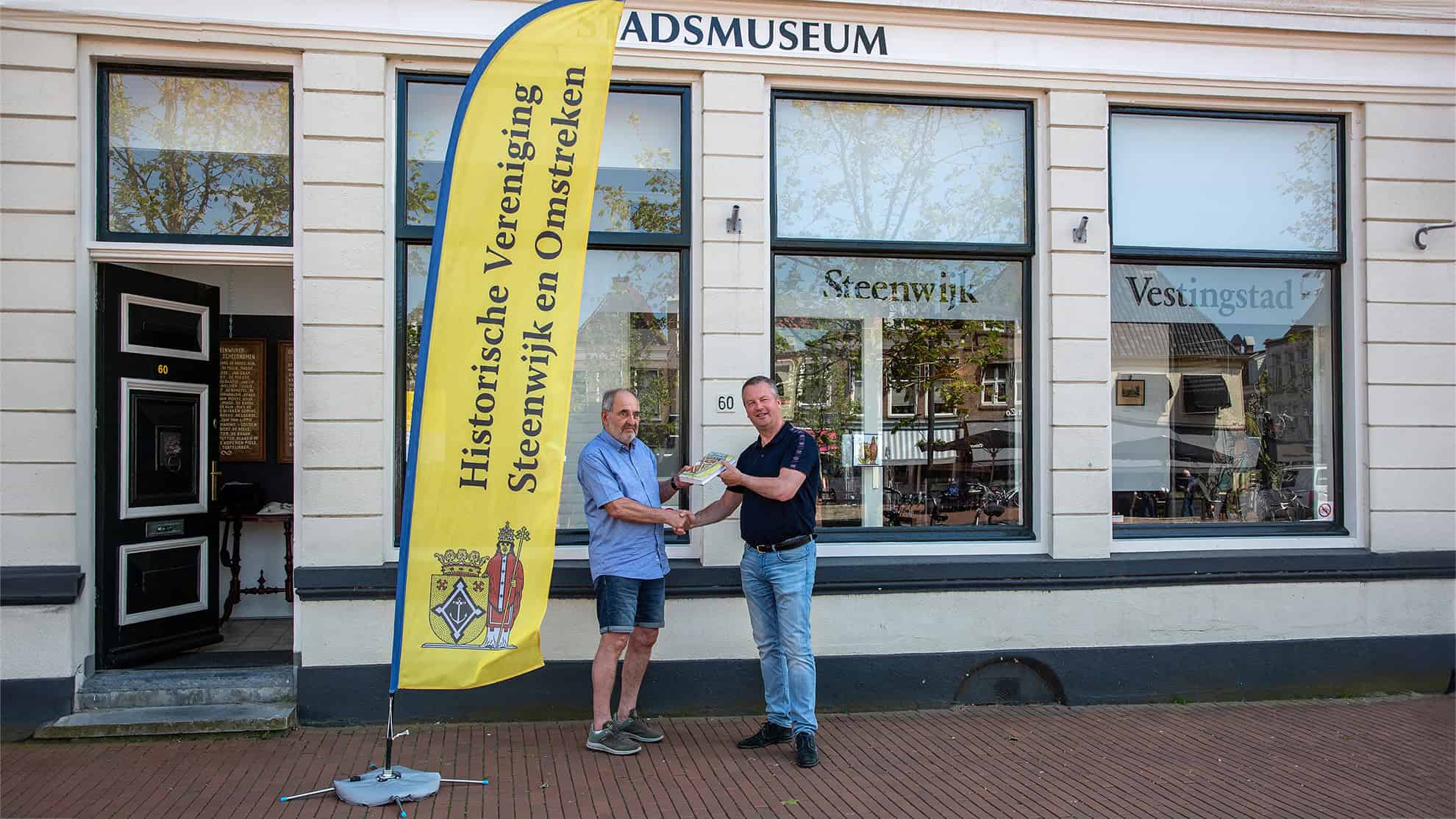 Op de foto feliciteert vicevoorzitter Bert Bos (links) het 1400ste lid Kees Brouwer. Hij ontvangt het boek “Steenwijk Vestingstad” als welkomstgeschenk. De foto is van Adri van Sleen.