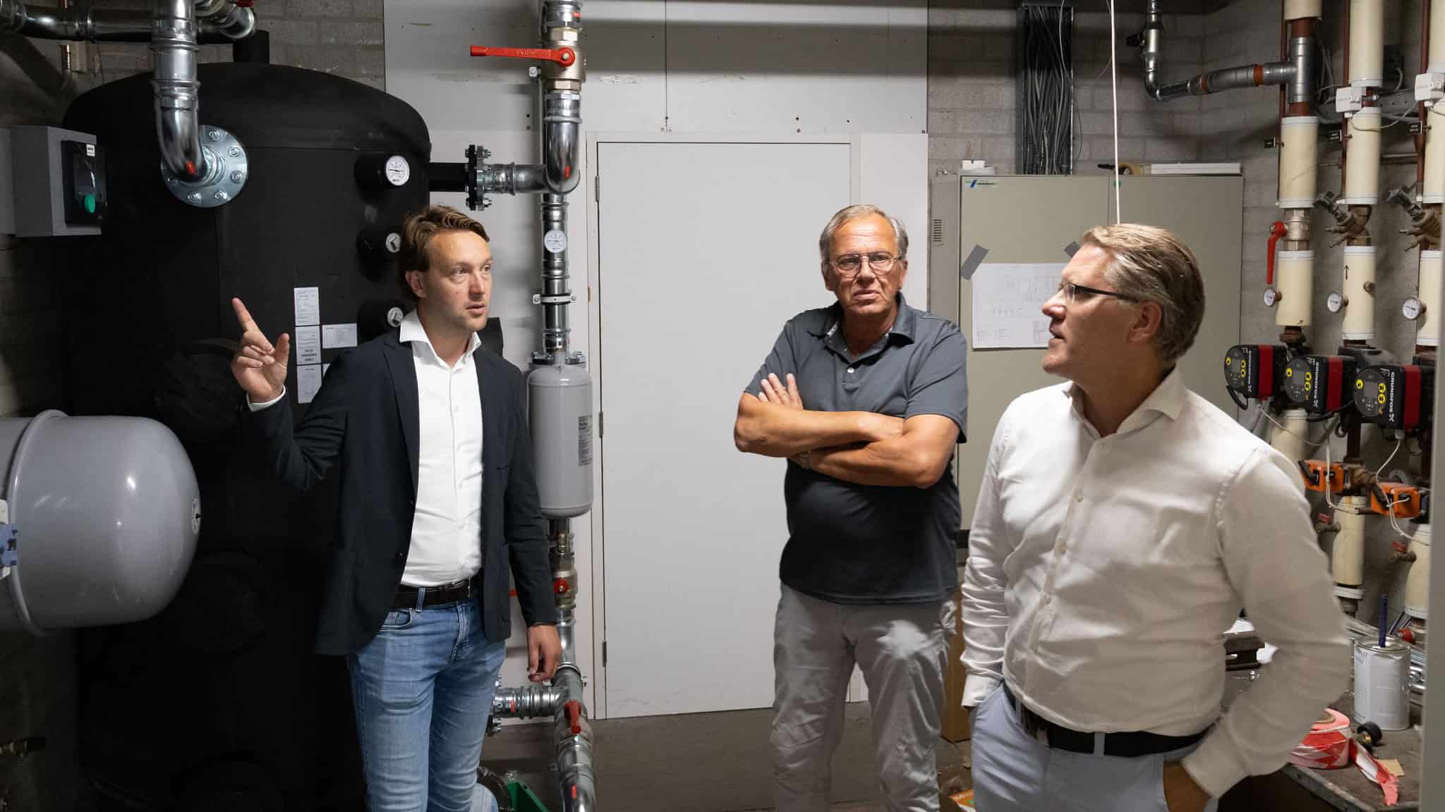 Wethouder Melvin Smit, Henk Veldkamp (voorzitter bestuur De Burght) en Ben Molema (gemeentelijk projectleider) in de vernieuwde installatieruimte van de Burght