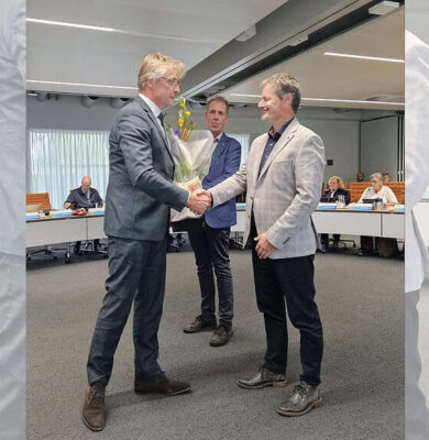 Uitreiking van een bloemenboeket tijdens een formele bijeenkomst bij RTV SLOS.