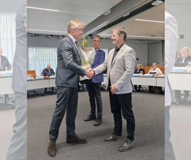 Uitreiking van een bloemenboeket tijdens een formele bijeenkomst bij RTV SLOS.