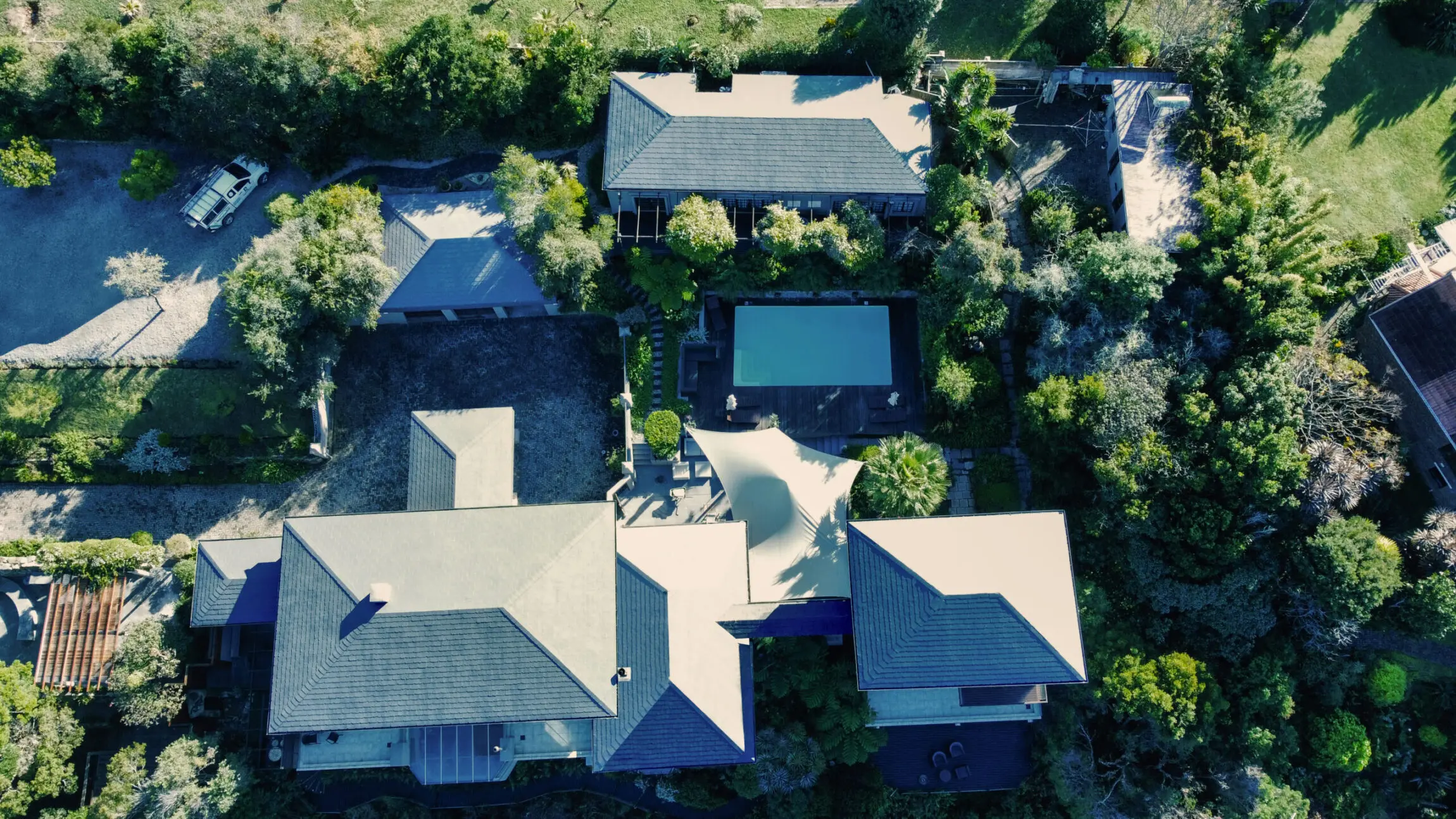 High-quality rubber roof installation on a residential property with lush landscaping and swimming pool, showcasing durability and weather resistance for roofing solutions.